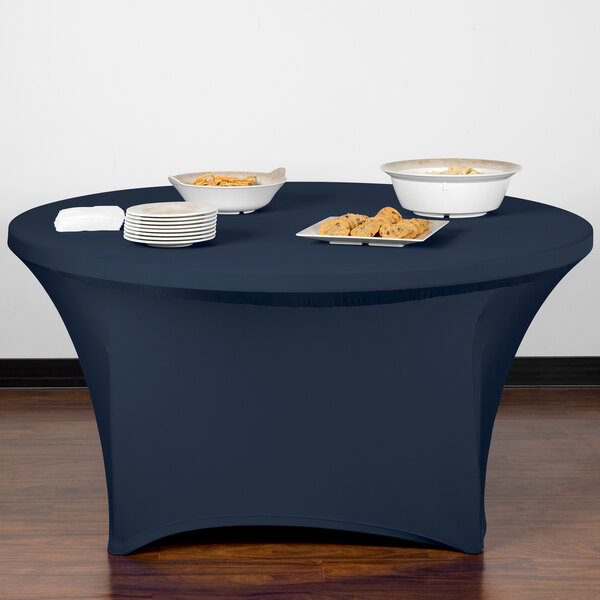A navy Snap Drape spandex table cover on a table with plates of food.