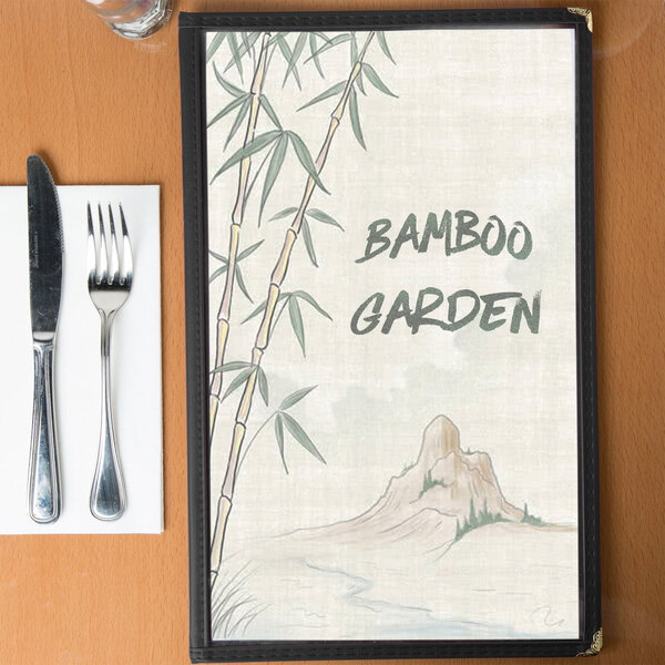 Menu cover with an Asian themed bamboo design featuring a mountain and utensils.