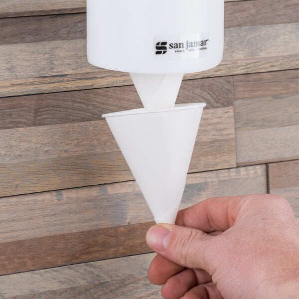A person's hand holding a white Bare by Solo cone cup.