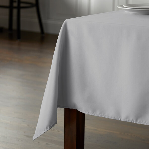 A table with a gray Intedge rectangular tablecloth on it.
