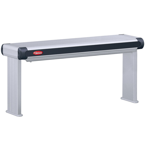A Hatco Glo-Ray Designer infrared strip warmer with a black metal shelf and red lights over a table.