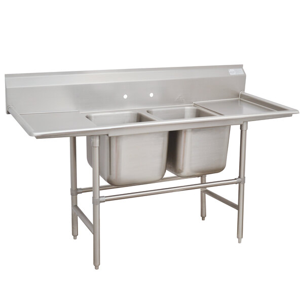 An Advance Tabco stainless steel two compartment pot sink with two drainboards.