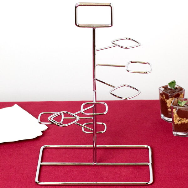 A chrome metal tower dessert shot display stand on a red tablecloth.