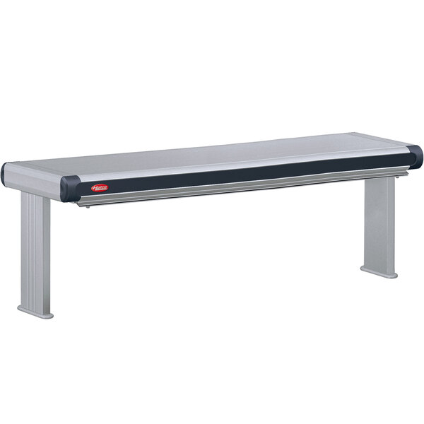 A long stainless steel rectangular Hatco strip warmer on a table with black and white frames.