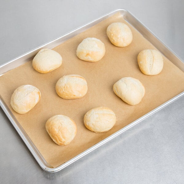 A Baker's Mark parchment paper sheet with rolls of bread on a tray.