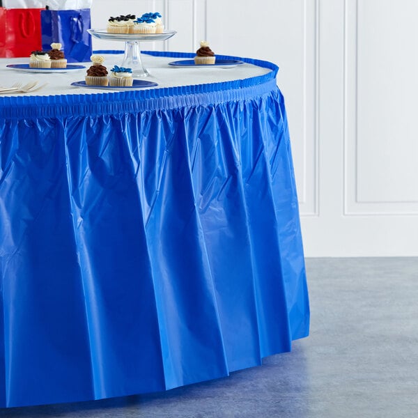 A table with a Creative Converting cobalt blue plastic table skirt on it.