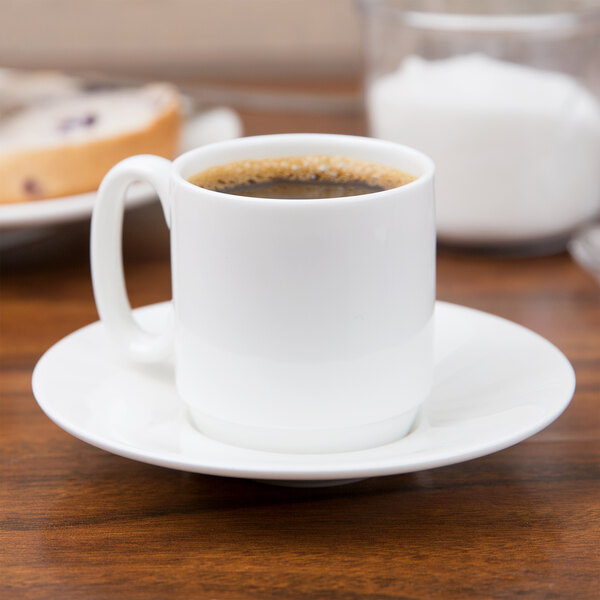 A 10 Strawberry Street white bone china espresso cup filled with brown liquid on a saucer.