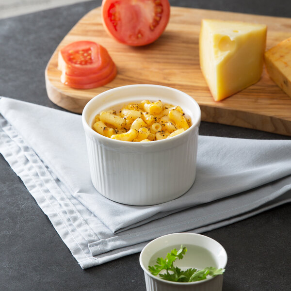 A white 10 Strawberry Street fluted ramekin filled with macaroni and cheese on a cutting board.