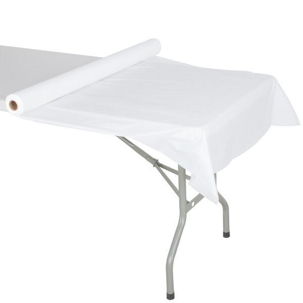 A roll of white plastic table cover on a table.