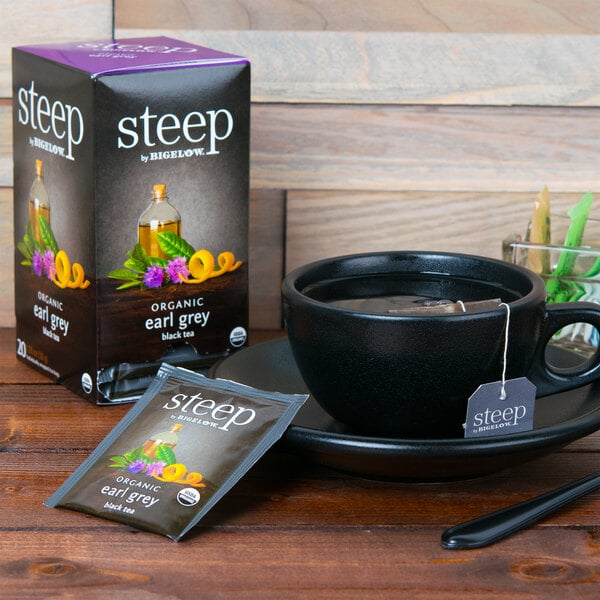 A box of Steep By Bigelow Organic Earl Grey Tea bags on a table next to a cup of tea.