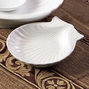 A CAC bright white china bowl with a shell-shaped design on the top.