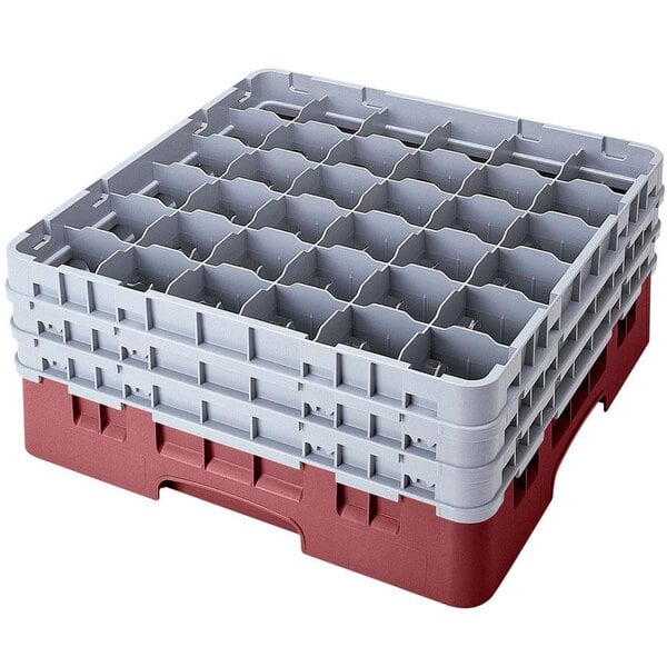 A red and gray plastic Cambro glass rack with many compartments.