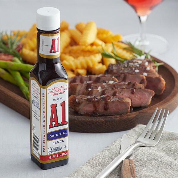A plate of steak and french fries with a bottle of A.1. Original Steak Sauce on the table.