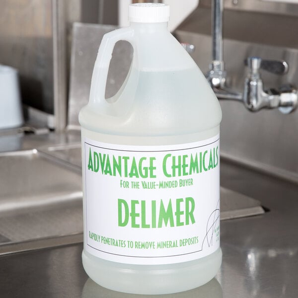 A jug of Advantage Chemicals delimer/descaler liquid with green text on a counter.