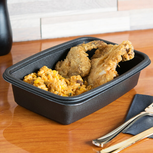 A black Genpak Smart-Set Pro rectangular container with food in it.