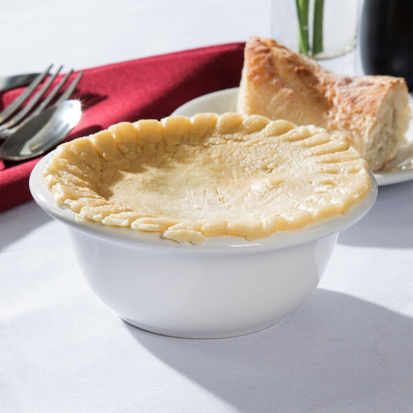 A white Tuxton china bowl filled with pot pie on a table.