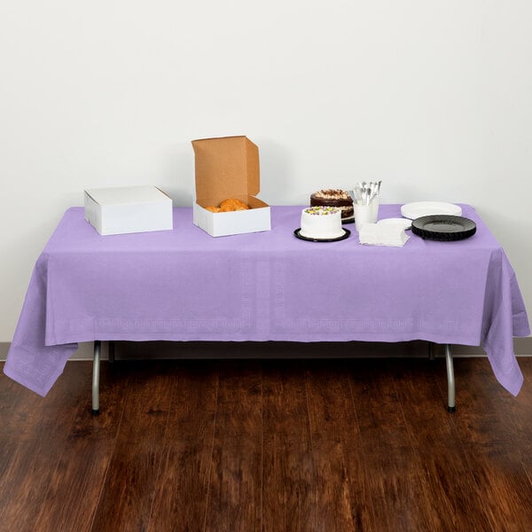 A table with food on it covered by a luscious lavender purple Creative Converting tablecloth.