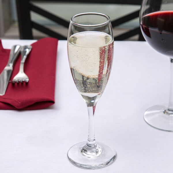 A Libbey flute glass filled with champagne on a table in a fine dining restaurant.