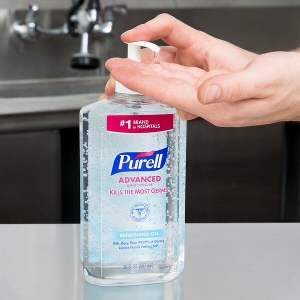 A person using a pump dispenser to get Purell Advanced Gel Hand Sanitizer from a bottle.