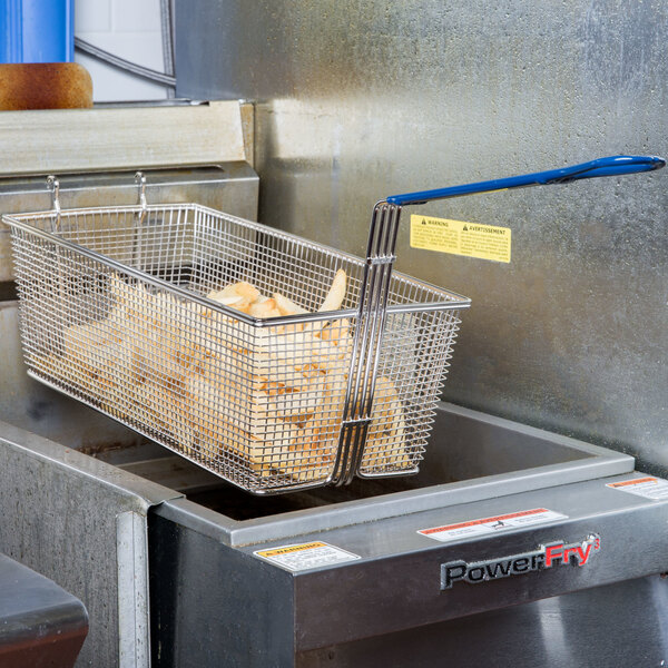 A Pitco twin fryer basket with food in a fryer.