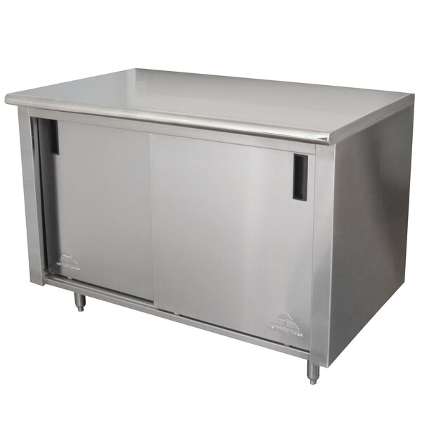 A stainless steel cabinet with doors under a stainless steel work table.