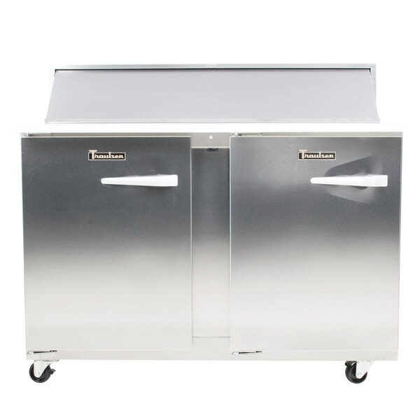 A silver Traulsen refrigerator with two left hinged doors on wheels.