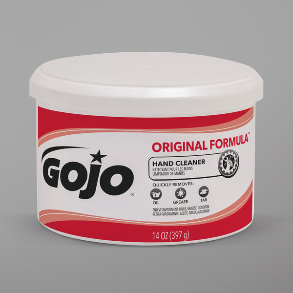 A white GOJO container with a red label for original formula hand cleaner on a kitchen counter.
