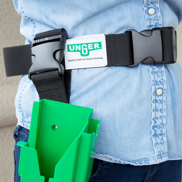 A person wearing an Unger TheBelt tool belt with a green plastic holder on it.