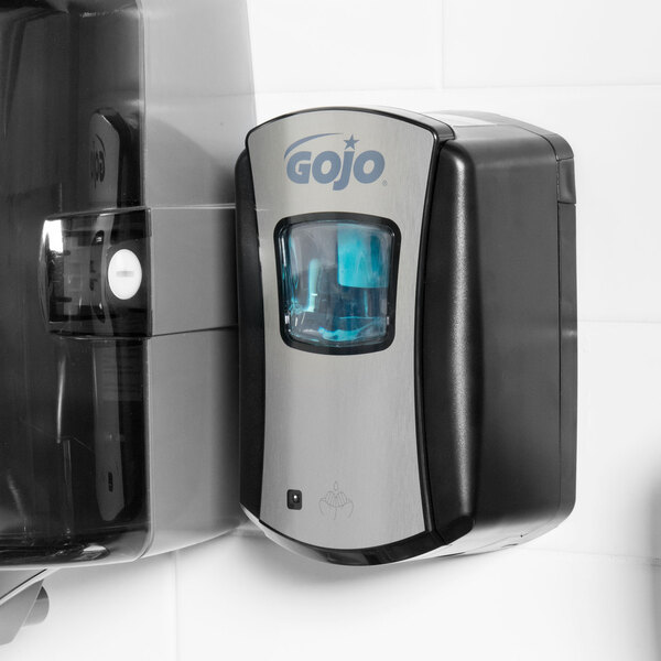 A GOJO touchless hand soap dispenser on a wall.