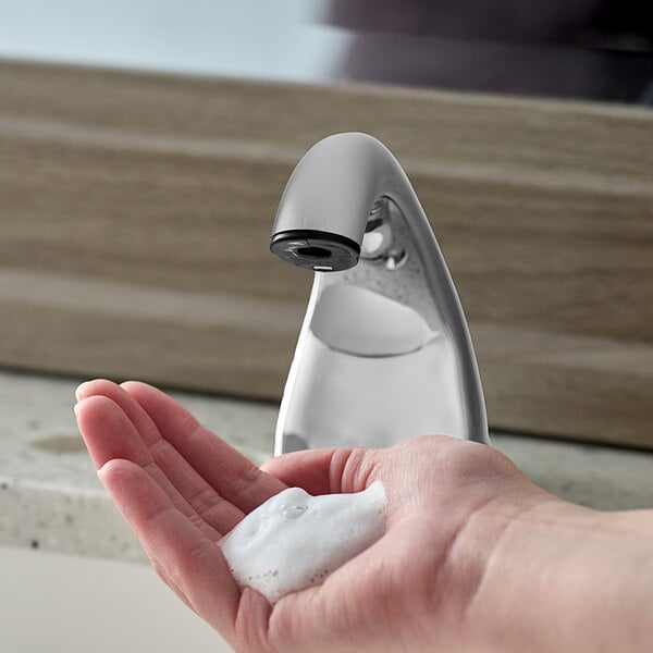 A person's hand using Purell CX Series foaming hand soap at a sink.