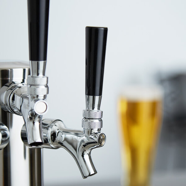 A black plastic Avantco beer tap handle on a silver and black tap.