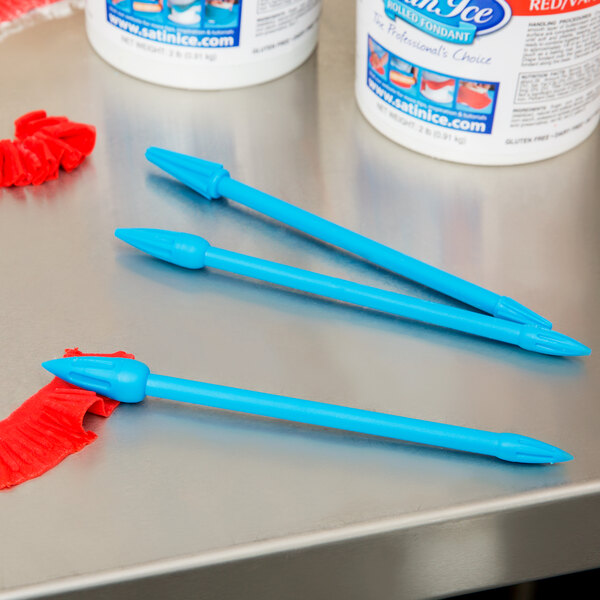 A white container with a blue label holding Ateco blue plastic ruffle tools.