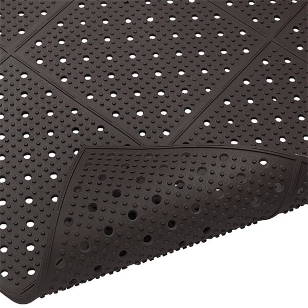 A black rubber Cactus Mat with holes in it.