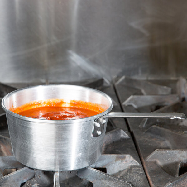 A Town tapered aluminum sauce pan with red sauce inside.