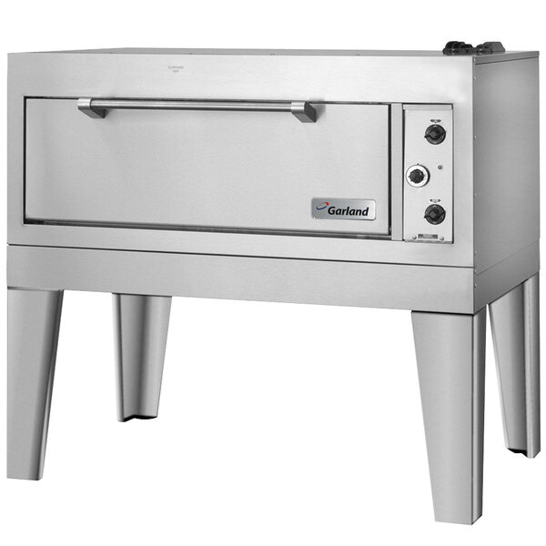 A stainless steel Garland triple deck oven with legs.