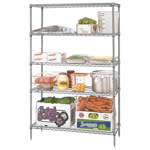 A Metro Super Erecta chrome wire shelving unit holding food items including grapes, carrots, and lettuce.