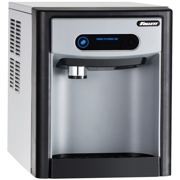 A Follett countertop ice maker and dispenser with a blue button and a screen.