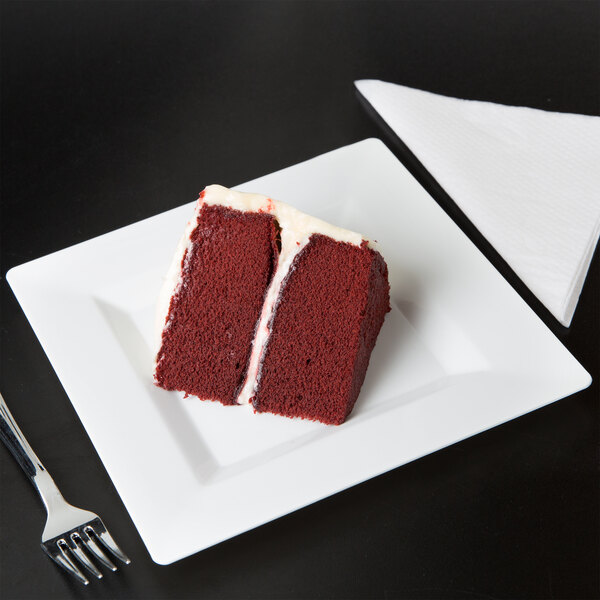 A piece of red velvet cake on a Visions white plastic plate.