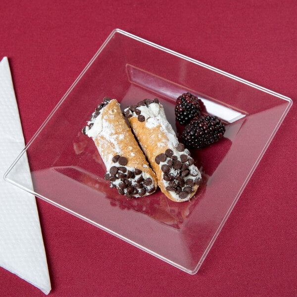 A Visions Florence clear square plastic plate with pastries and berries on it.