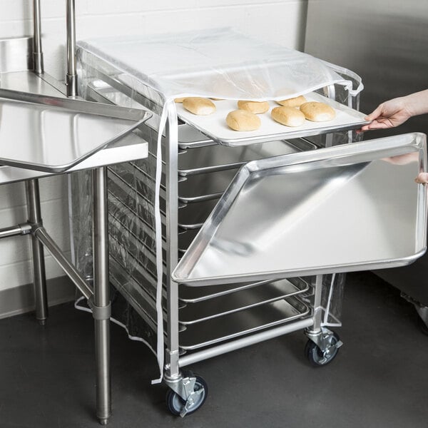 A woman using a Regency sheet pan rack to hold a tray of bread.