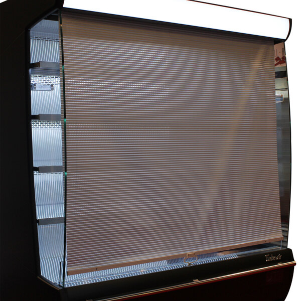 A close up of a Turbo Air night cover over a window in a white display case.
