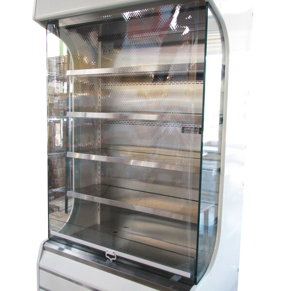 A Turbo Air night cover on a glass display case with shelves.