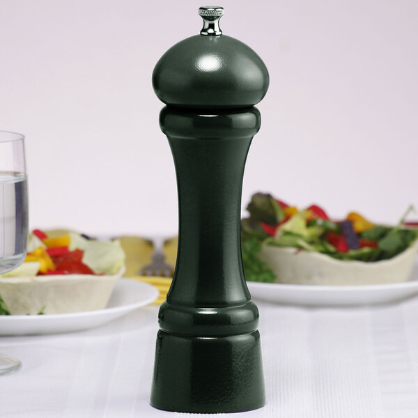 A Chef Specialties forest green pepper mill on a table.