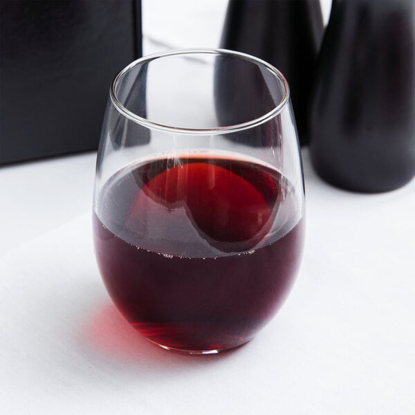 A close up of a Libbey stemless wine glass filled with red wine on a table.