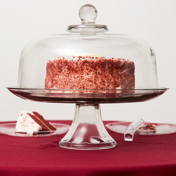 An Anchor Hocking glass cake dome over a cake on a glass stand.