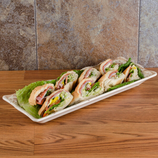 A rectangular melamine display tray with sandwiches on a table.