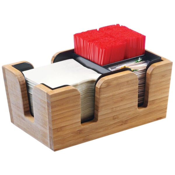 A Cal-Mil bamboo bar caddy with a stack of napkins and red straws.