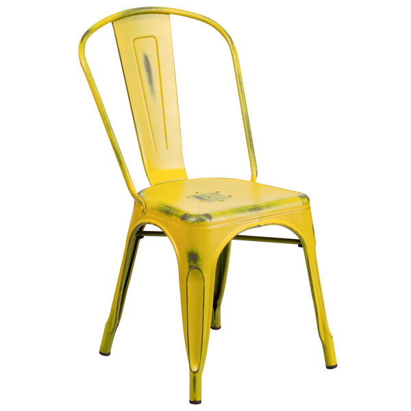 A yellow metal Flash Furniture restaurant chair with a vertical slat back and drain hole seat.