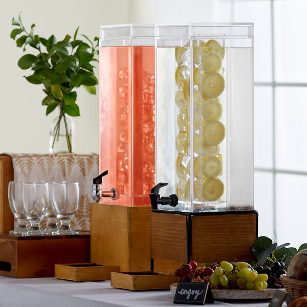 A Cal-Mil Madera rustic pine beverage dispenser with fruit in it on a buffet table.