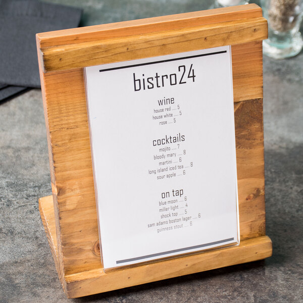A wood Cal-Mil Madera displayette with a menu on it on a table.